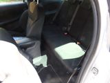 two seats in the back of a car with a green seat pad