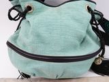 mint green handbag with black trim and tassels