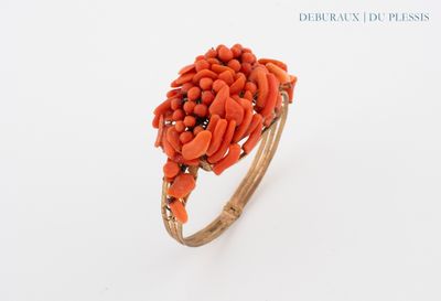 an image of a ring with orange coral stones on it