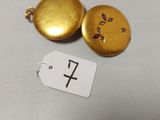 un petit cadenas doré orné d'une croix et muni d'une étiquette