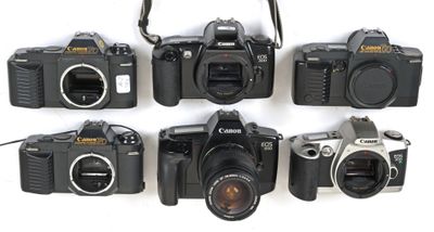 several cameras are lined up in a row on a white surface