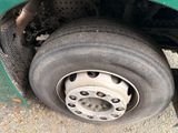 a close up of a flat tire on a green truck