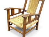 an image of a wooden chair with a wicker seat and arm rest