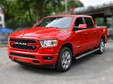 Le camion rouge de la marque Ram est garé sur un parking près d'un pont