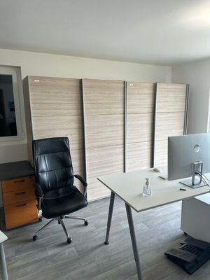 un bureau avec un ordinateur et une chaise dans une pièce