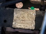 a close up of a metal plate with a green button