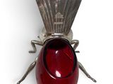 a small red object with a silver bug on it
