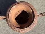 a rusted metal bowl with a hole in it
