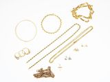 an assortment of gold jewelry including a necklace, bracelet, and ring