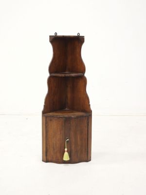 a small wooden shelf with a bell on it