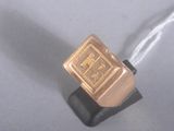 une photo d'une bague en or posée sur un socle noir