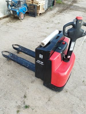un chariot élévateur à fourche garé au sol devant un bâtiment