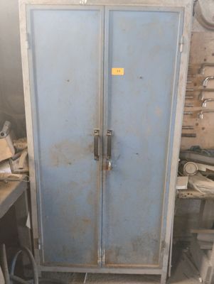 a blue metal cabinet in a room with tools on the table