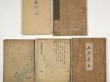 three old books with asian writing on them sitting next to each other