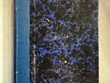 un livre bleu et noir posé sur une surface blanche