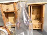 a glass vase sitting next to a clock on a table