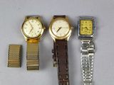 trois montres différentes sont posées les unes à côté des autres sur une table