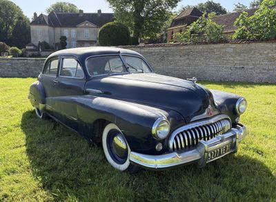 une voiture noire garée dans l'herbe