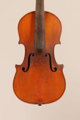 an old violin sitting on top of a white surface