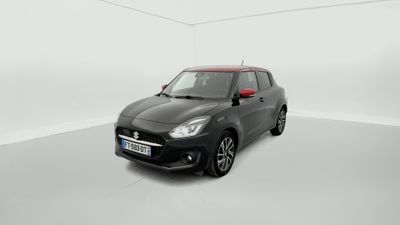 Une petite voiture noire est garée dans une pièce blanche.