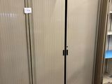a suitcase sitting on the floor in front of a storage unit