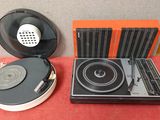 une platine et des haut-parleurs posés sur une table recouverte d'une nappe rouge