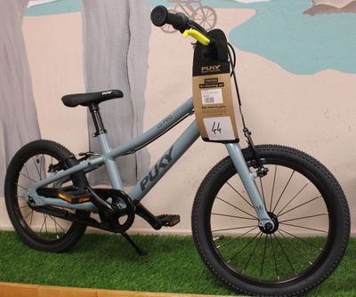 a bicycle that is sitting on the grass in front of a wall