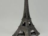 an image of a small silver statue of the eiffel tower