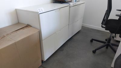 un bureau sur lequel est posé un ordinateur, à côté d'un classeur