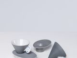 deux bols et une assiette avec une cuillère posés sur une table blanche