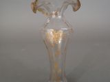 a clear glass vase with a gold decoration on it