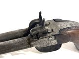 a close up of a gun with a wooden handle on a white background