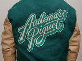 the back of a man wearing a green and tan jacket