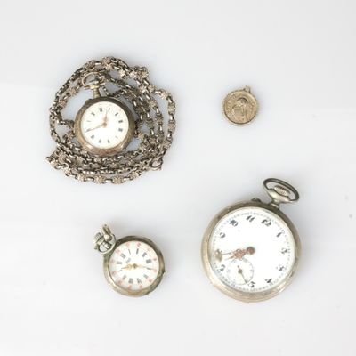 trois types de montres différents et une pièce de monnaie posés sur un fond blanc