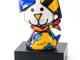 brightly colored cat figurine on black base on white background