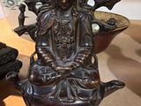 une statue représentant une femme assise sur une théière