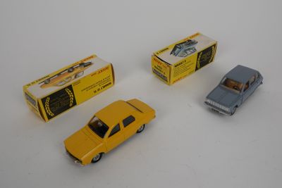 Trois petites voitures sont posées les unes à côté des autres sur une surface blanche.