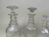three clear glass bottles sitting next to each other on a table