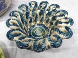 a blue and white bowl sitting on a table next to a vase
