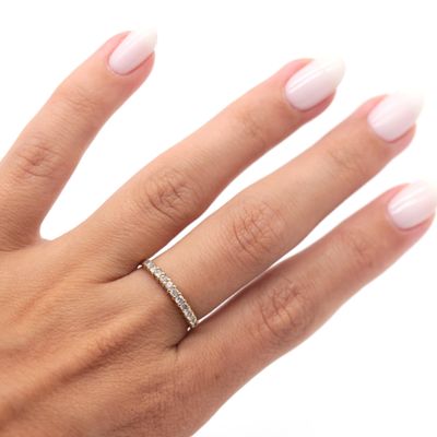 the woman ' s hand is holding a diamond ring on her finger