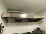 a stainless steel range hood in a kitchen with a stove
