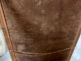 a brown piece of luggage sitting on a white table