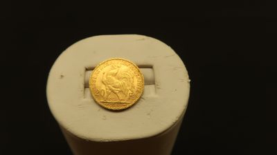 a gold coin sitting on top of a white object
