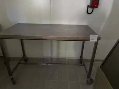 une table en acier inoxydable sur laquelle est posée une pancarte