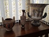 trois vases posés sur une table devant une fenêtre