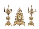 trois horloges de couleur dorée disposées les unes à côté des autres sur un fond blanc