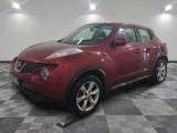 une photo d'un SUV Nissan Juke rouge garé dans un garage