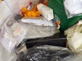 many bags of food in a trash can on the floor