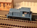 a blue train on the train tracks near a building