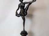 bronze statue of a woman holding a ballerina on a glass table